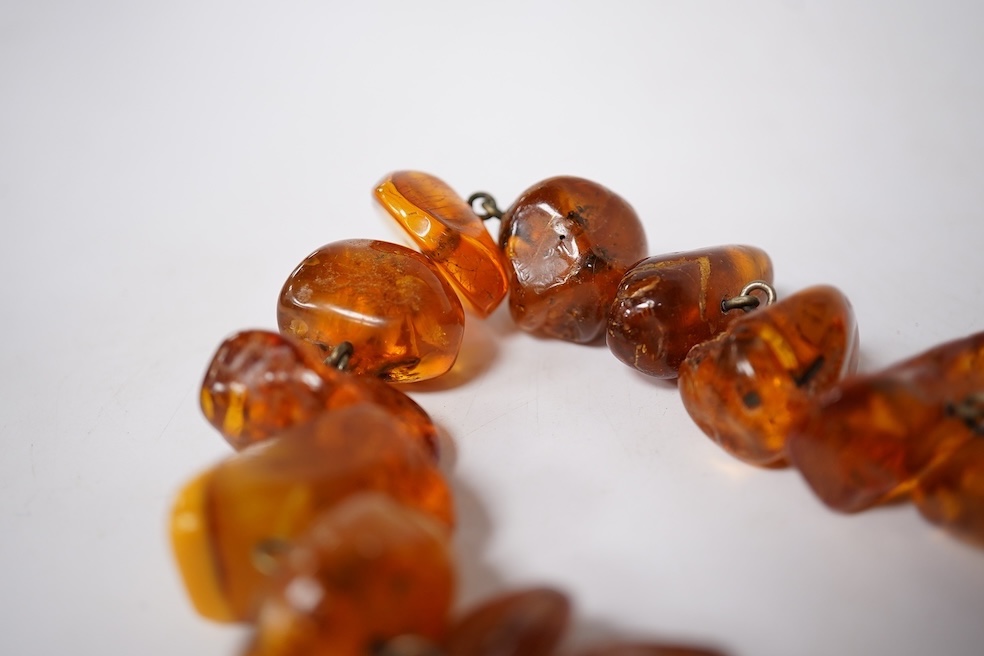 Three assorted amber necklaces including a single strand graduated oval bead necklace, 40cm, gross weight 37 grams, the other two necklaces gross weight 240 grams. Condition - poor to fair